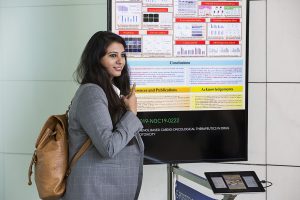 A woman standing next to an e-poster
